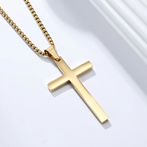 Detail of 18K gold plated cross pendant with elegant box chain on a white background