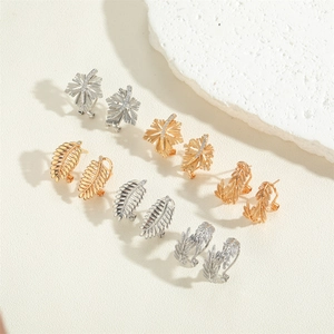 Detailed view of 14K gold and silver leaf-shaped earrings with fine crystal accents