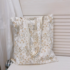 Detail of vintage rabbit and wildflower print on cream canvas tote with fabric label