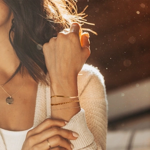 Vue détaillée de bracelets superposés en or avec chaîne serpent et maillons au poignet