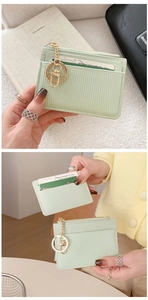 Detail of light green coin purse with vertical stripes, card slots, and key chain hook
