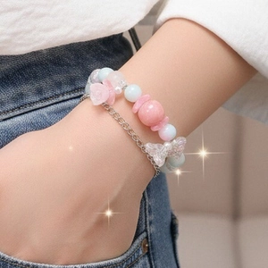 Pulsera de doble capa con cuentas y detalle de lazo de cristal en la muñeca de mujer