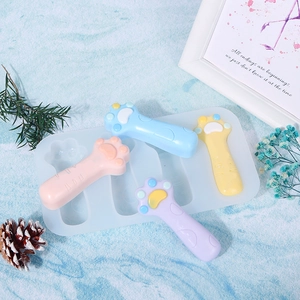 Vista dall'alto dello stampo in silicone a zampa di gatto con manici colorati su marmo blu