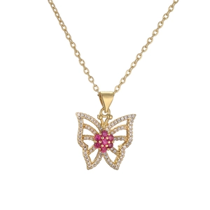 Detailed macro view of gold butterfly pendant with red and white crystal accents