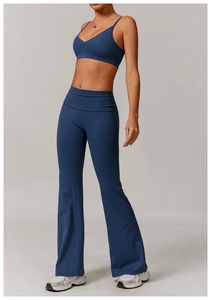 Detail of dark blue V-neck sports bra and high-waisted flared yoga pants on model