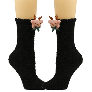 Detail von schwarzen Plüschsocken mit 3D Rentierpuppe und grüner Schleife für Weihnachten