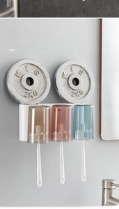 Wall-mounted toothbrush holder showing high weight capacity with 2kg weights on marble wall