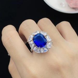Macro detail of a silver ring featuring a deep blue gemstone and pear-shaped accents
