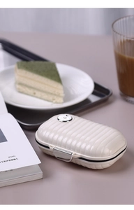 Mini portable pill box with textured horizontal stripes and secure metal latch detail