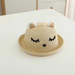 Dettaglio di un cappello di paglia per bambini con orecchie di gatto e ricamo carino