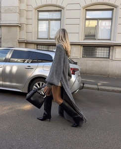 Détail d'un cardigan gris en maille épaisse avec boutons latéraux et manches longues