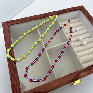 Detail of colorful beaded necklaces with yellow, green, red and blue beads in a jewelry box