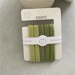 Detailed view of 5-pack elastic hair ties in gradient green on minimalist packaging