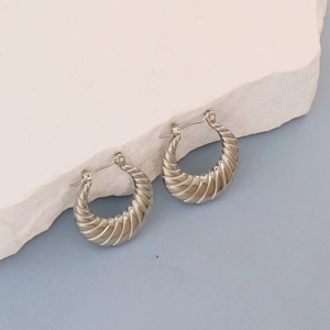 Minimalist silver croissant hoop earrings with ribbed texture on artistic stone