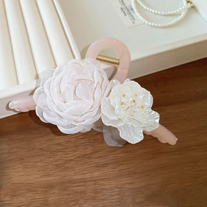 Dettaglio della molletta rosa con rosa in pizzo e fiori eleganti su sfondo decorativo