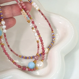 Close-up of colorful crystal beads and natural pearls on a stainless steel necklace