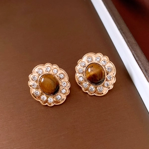Dettaglio degli orecchini vintage a fiore con pietra occhio di tigre e placcatura