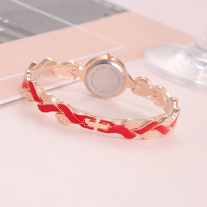 Macro view of gold and red alloy watch with a stainless steel back and leaf bracelet
