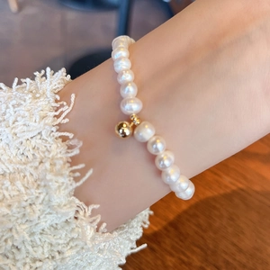Close-up of a natural freshwater pearl bracelet with a 14K gold-filled bead on wrist