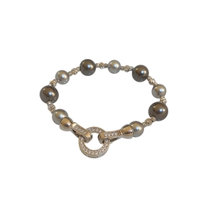 Armband mit unregelmäßigen Perlen und goldener Zirkonia-Ringschließe auf weißem Grund