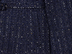 Nahaufnahme von dunkelblauem Tweed-Stoff mit gewebten weißen Fäden und goldenen Pailletten