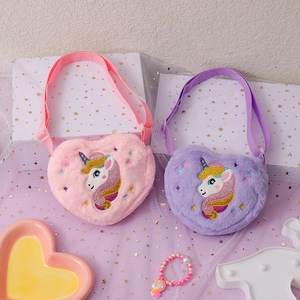 Detail of plush heart-shaped bags with unicorn embroidery and soft faux fur texture