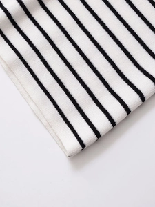 Close-up of the black and white striped knit fabric and fine hemline texture detail