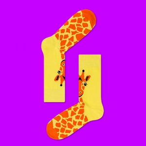 Detail of yellow cotton socks with orange giraffe pattern on bright purple backdrop