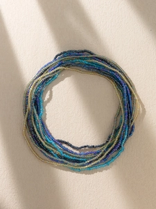 Detailed macro view of bohemian multi-color seed bead waist chains in circular arrangement
