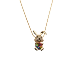 Close-up of a gold bunny necklace with sparkling zircons and a colorful gemstone