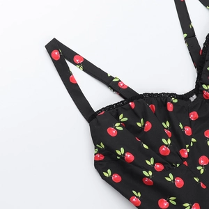 Detailed view of V-neckline with red cherry print and delicate lace trim on dress