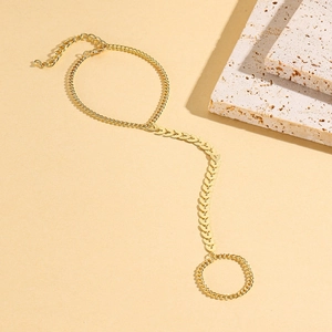 Detailed view of golden leaf-shaped links on a slave bracelet with ring and chain
