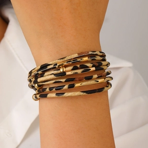 Detail of multi-layer leopard print leather bracelet with gold metallic accents for women