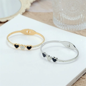 Dettagli di bracciali a cuore con smalto nero e strass scintillanti su anello aperto