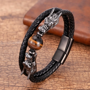 Macro detail of braided leather bracelet featuring a metal dragon head and tiger eye stone