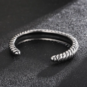 Close-up of vintage silver dragon scale bracelet with punk twist texture on black background