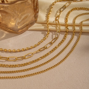 Minimalist gold layered chains featuring paperclip and ball links for a stylish look