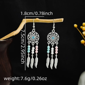 Detailed view of silver dreamcatcher earrings with feathers and colorful beads