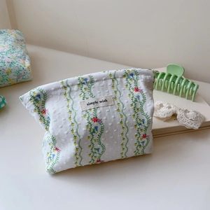 Close-up of green floral quilted cotton makeup bag with Simple Wish brand label