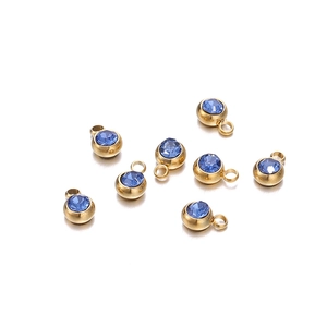 Détail de huit pendentifs ronds en acier doré 6mm avec cristaux de pierre de naissance bleus
