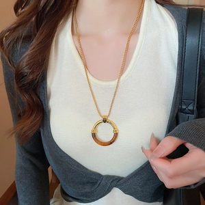 Dettaglio della collana con pendente rotondo geometrico in resina stile vintage