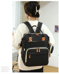 Detail of black multifunctional diaper backpack featuring quilted diamond pattern on back view