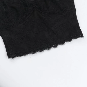 Close-up of intricate black lace crochet patterns and jagged scalloped edge detail