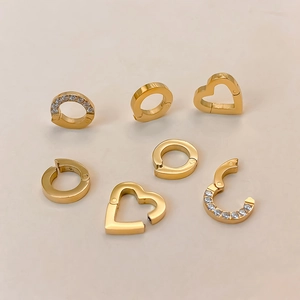 Detailed macro view of gold-plated stainless steel heart and round jewelry connectors for DIY