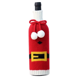Knitted Santa Claus wine bottle cover with red festive pattern and white pom poms