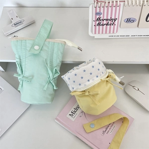 Detailed view of pastel macaron-colored fabric pencil bags with star-patterned lining
