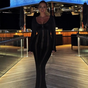 Detail of elegant black U-neck long sleeve dress with vertical ribbed texture knit