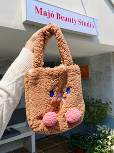 Cute teddy plush brown handbag with cartoon embroidery and pink pompoms on the bottom