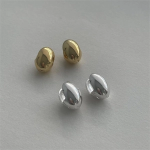 Polished minimalist bean stud earrings in silver and gold finishes on a textured background