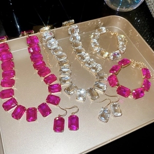 Detailed close-up of sparkling square-cut crystal necklace and bracelet set in jewelry tray